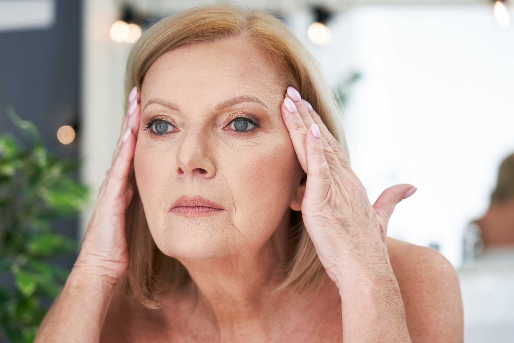 Senior Woman Using Anti-Wrinkle Cream in the Bathroom